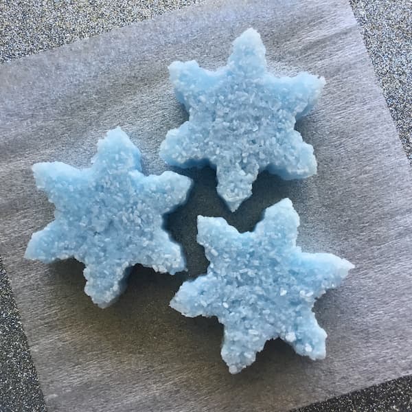 three light blue bath salt cakes in the shape of snowflakes