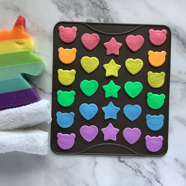 a macaron mat filled with rainbow coloured melt and pour soap