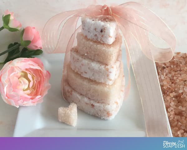 heart shaped pink himalayan bath salt caked stacked in a tower formation with a pale pink ribbon on top