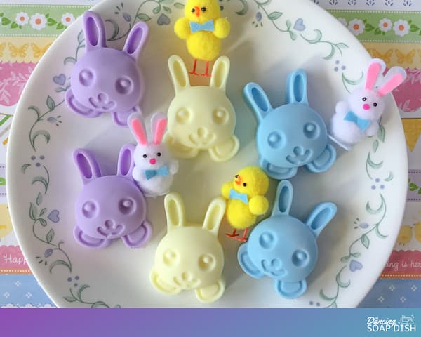 purple, yellow and blue bunny soaps sitting on a round white plate