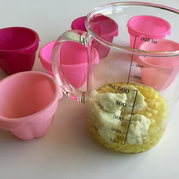 baking cups and glass mixing jug containing shea butter, bees wax and coconut oil