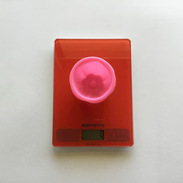 top view of pink baking cup sitting on red kitchen scales