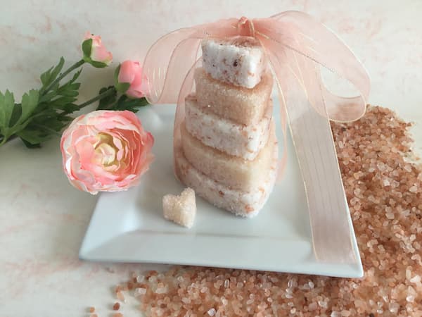 a tower of heart-shaped pink himalayan bath salt cakes with a ribbon on top