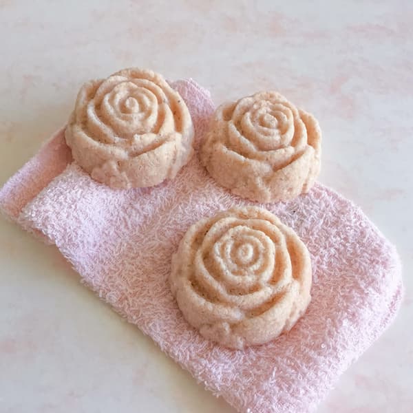 three pink himalayan salt bath salt cakes in the shape of a rose