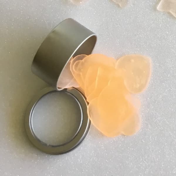 super thin orange soap confetti falling out of a metal cannister