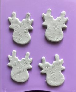 four reindeer shaped cut outs of white clay