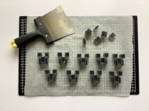 a cutting mat, a large paint scraper and nine sets of minecraft creeper face soap embeds