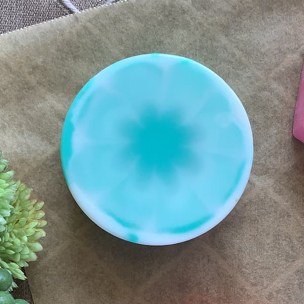 a round soap bar with a green and white tie dye effect