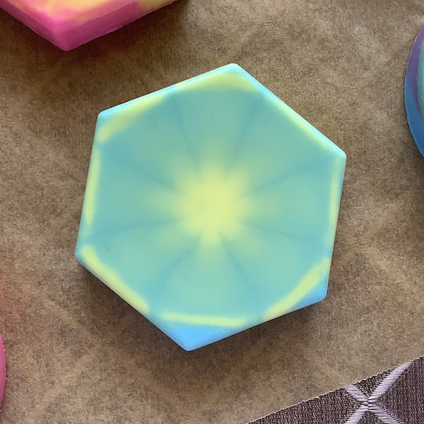 a hexagonal soap bar with a yellow and blue tie dye effect