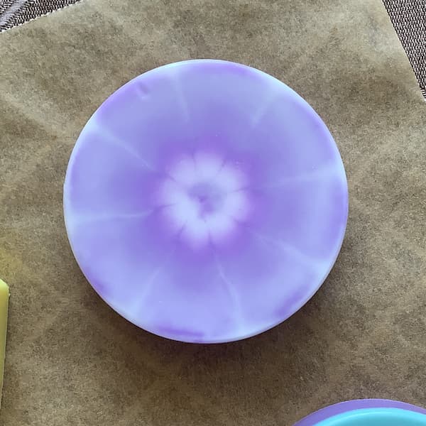 a round soap bar with a purple and white tie dye effect