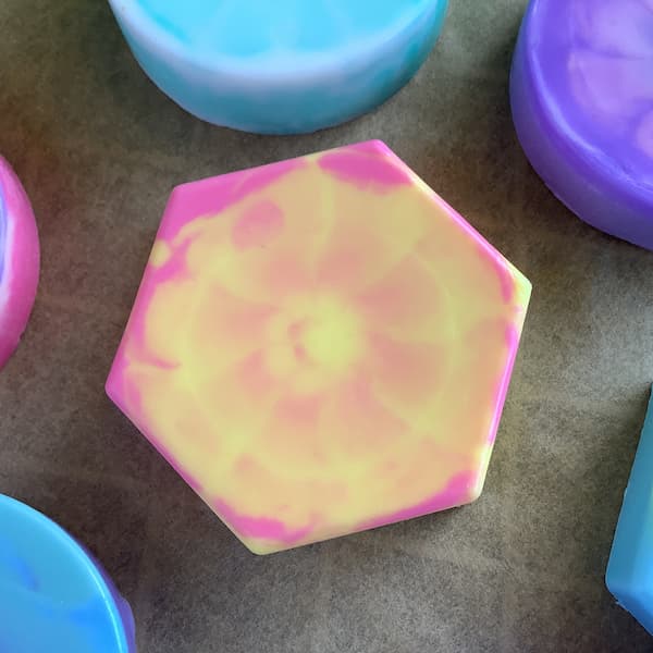 a hexagonal soap bar with a yellow and pink tie dye effect