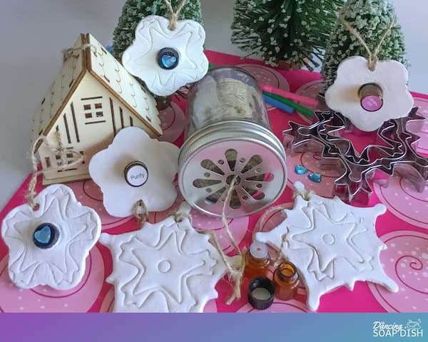 snowflake diffuser ornaments laid out with 1ml amber glass vials, snowflake pastry cutters and hessian twine