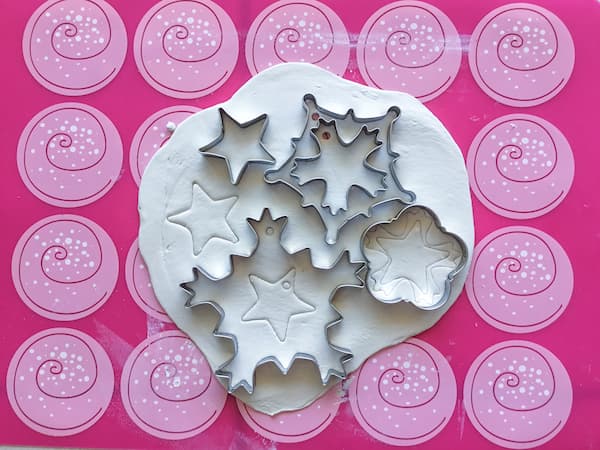 snowflake shaped pastry cutters on a white piece of clay
