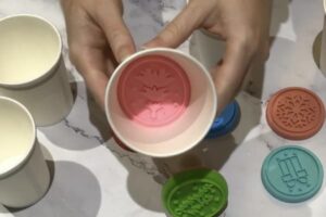 a paper cup with a silicone cookie stamp in it