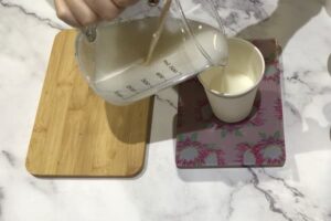 pouring white melt and pour soap base into a paper cup