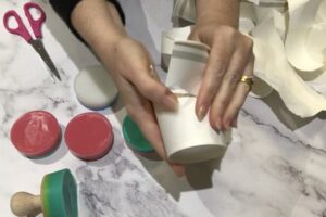 tearing open a paper cup to release a bar of soap inside it