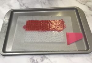 a mosaic tile silicone mould filled with red soap base