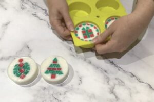 two hands removing mosaic Christmas soap from a soap mould