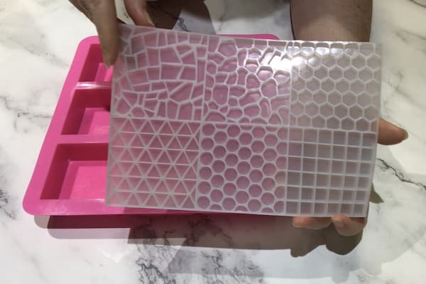 two hands holding up a mosaic tile silicone mould
