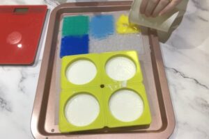 filling a mosaic tile silicone mould with various coloured soap bases