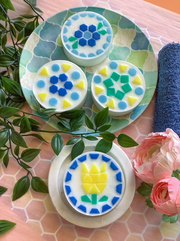 mosaic soap bars with various designs laid out in royal blue, green, light blue, and yellow mosaic soap tiles