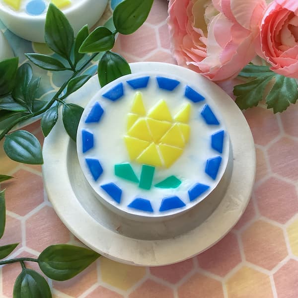 a round soap bar covered with mosaic soap tiles laid out in the shape of a tulip
