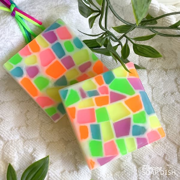 two square soap bars covered with neon coloured mosaic tiles