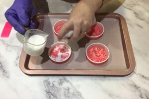 pouring melted white soap base into to cavity of a silicone ornament mould