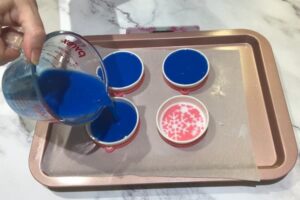 pouring blue soap base into soap moulds