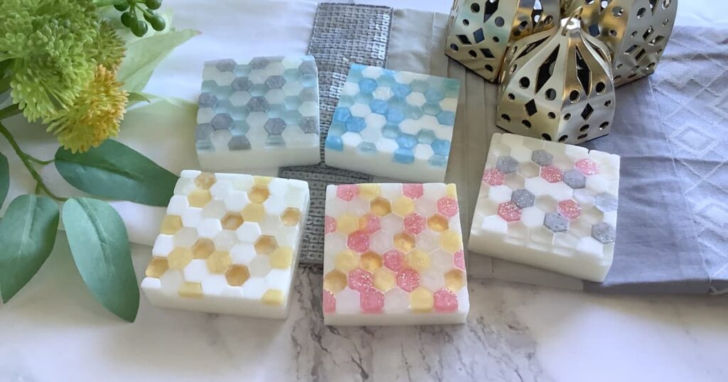 five glass tile effect soap bars laid out on a grey background