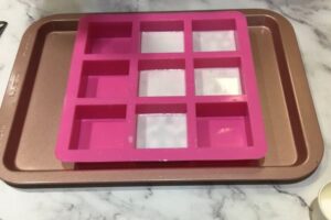 five partially filled square soap moulds