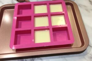 five freshly poured soap bars sitting in a square soap mould