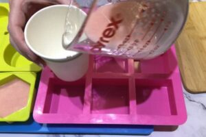 pouring rose gold coloured soap into a paper cup