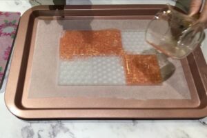 a mosaic tile silicone mould partly filled with rose gold coloured soap