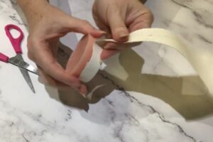a pair of hands tearing a round bar of soap from a paper cup