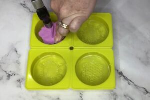 stamping the surface of a bar of soap with a mandala stamp