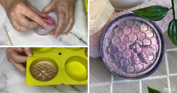 A three‑panel collage demonstrates an inlay technique used in melt and pour soap making. Two panels on the left show a hand pulling back a silicone inlay from the surface of a clear, round, half bar of soap, and the surface of the soap after it has been painted with colour-changing mica. The panel on the right displays the finished round soap, coloured in shimmering shades of purple and pink with a metallic sheen. A raised bee sits at the centre of a honeycomb design, creating a detailed embossed effect. The soap is presented on a textured surface with soft pastel towels, a bath sponge, and green leaves, giving the scene a spa‑inspired look.