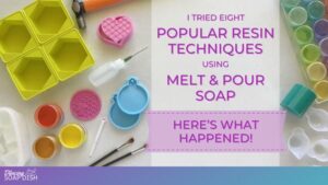 A title graphic for a soap‑making tutorial reads, “I Tried Eight Popular Resin Techniques Using Melt & Pour Soap: Here’s What Happened!” in purple text on a white background. Surrounding the text are colourful craft supplies including moulds in hexagon, heart, and ornament shapes, small containers of pigment, paintbrushes, a squeeze bottle, measuring spoons, and a tray holding small platic cannisters filled with different coloured mica powders.